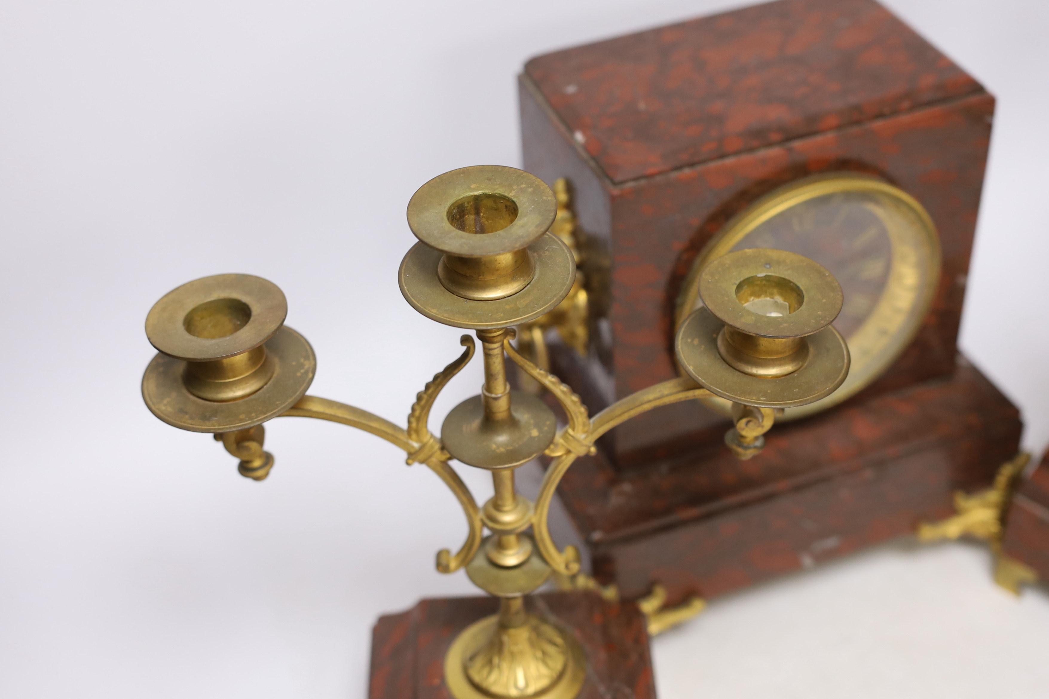 A late 19th century French rouge marble and ormolu clock garniture, 31cm